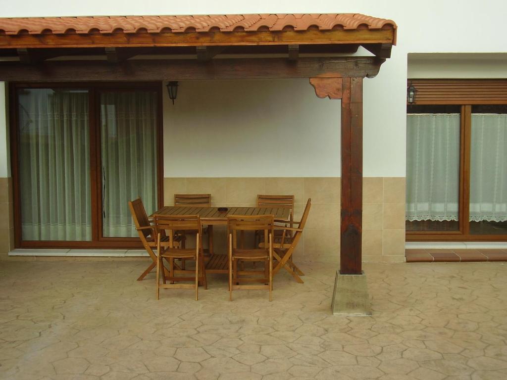 a wooden table and chairs under a pavilion at La Pergola in Santillana del Mar