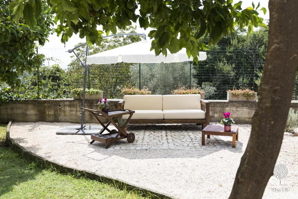 a patio with a white couch and an umbrella at Domus Citri in Caserta