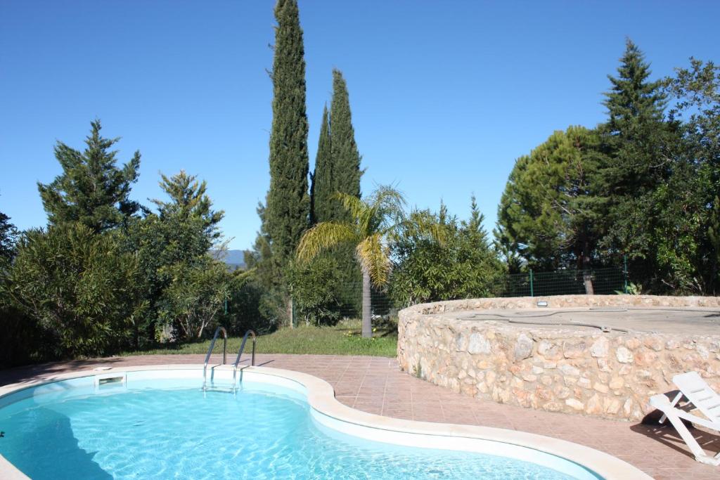 ein Pool mit einer Steinmauer um ihn herum in der Unterkunft Quinta Teresinha in Silves