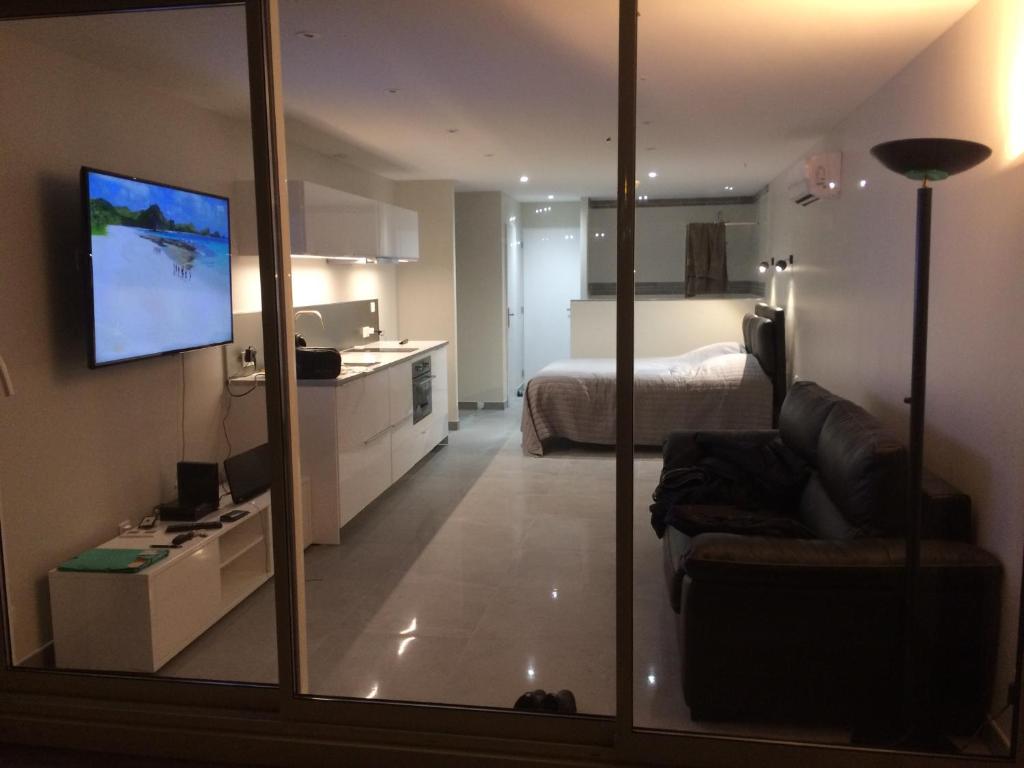 een woonkamer met een bank en een slaapkamer bij HELIOPOLIS CAP D'AGDE VILLAGE NATURISTE in Cap d'Agde