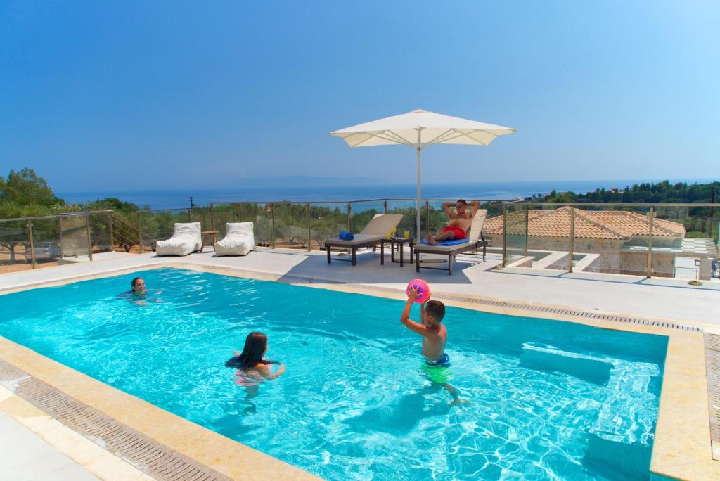 un groupe de personnes jouant avec un frisbee dans une piscine dans l'établissement Villa Ion Pangea Villas, à Trapezaki