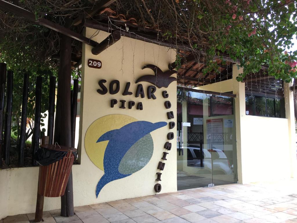 um sinal de pizza solar na lateral de um edifício em Condomínio Solar Pipa em Pipa