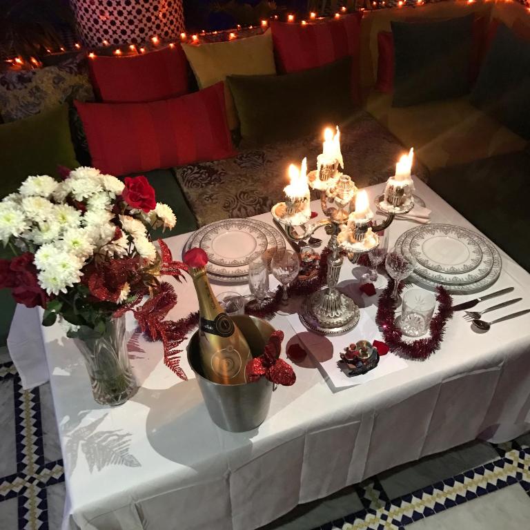 a white table with candles and flowers on it at Riad Amor - Suite & Spa in Fès