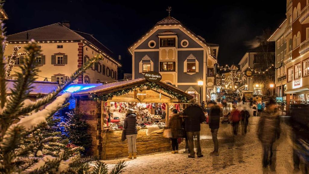 een groep mensen die rondlopen op een kerstmarkt bij Ortisei - Nel cuore delle Dolomiti in Ortisei
