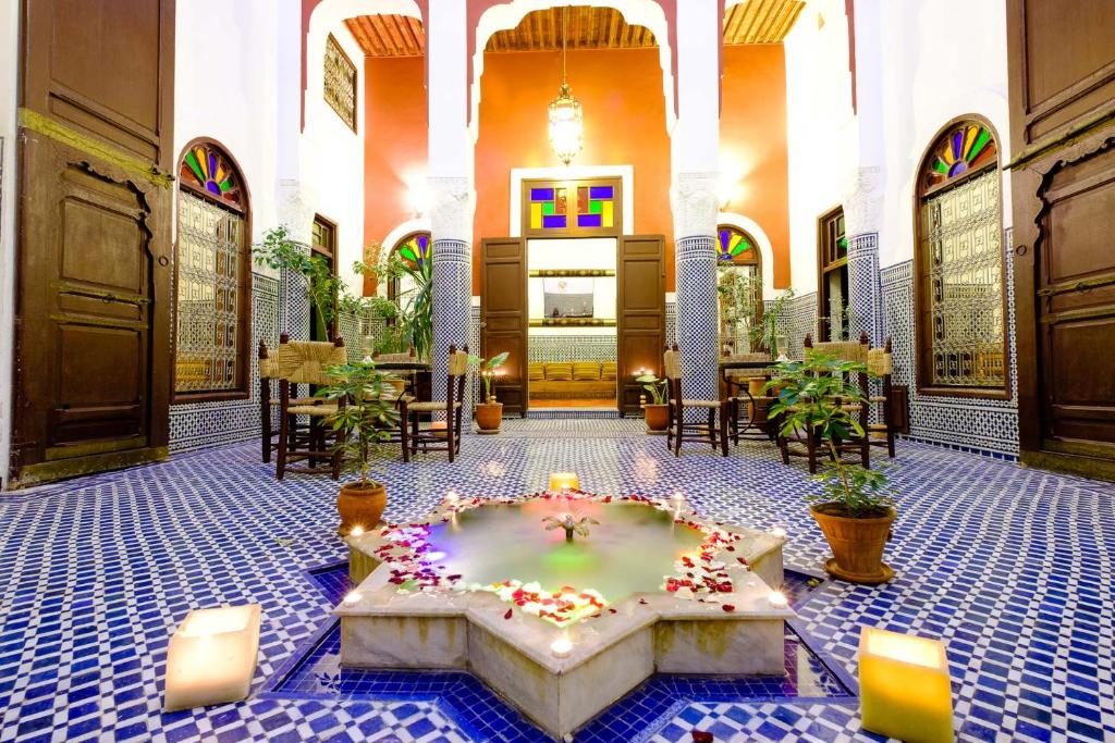 un vestíbulo con una gran habitación con una gran bañera con velas en Riad Tafilalet, en Fez