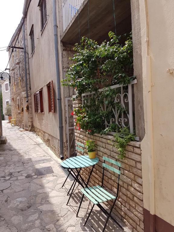 a couple of chairs sitting next to a building at Apartment Slava in Primošten