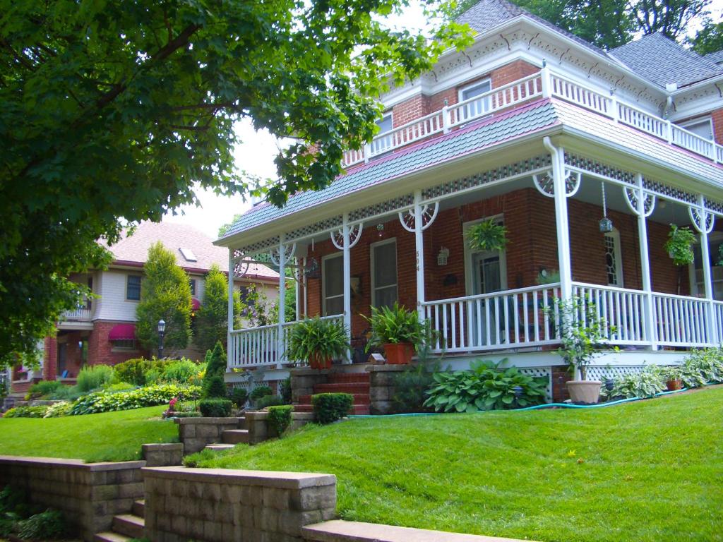 una casa de ladrillo rojo con porche blanco en Main Street Inn en Kansas City