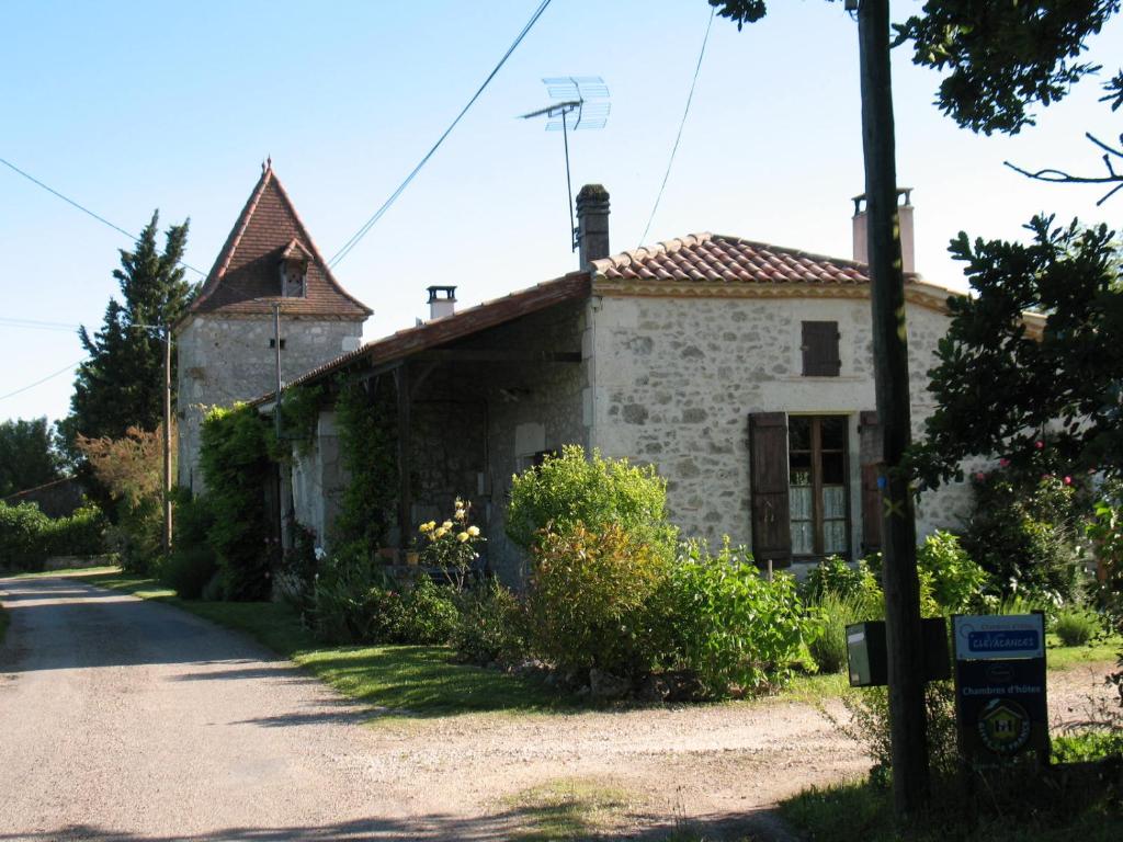 an old stone building with a tower on a street at Chambre d'Hôtes Le Pigeonnier de Quittimont in Lacépède