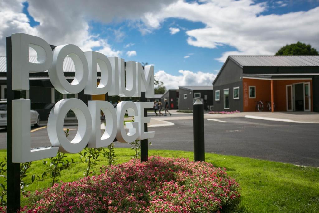 a sign in front of a building with a house at Podium Lodge in Cambridge