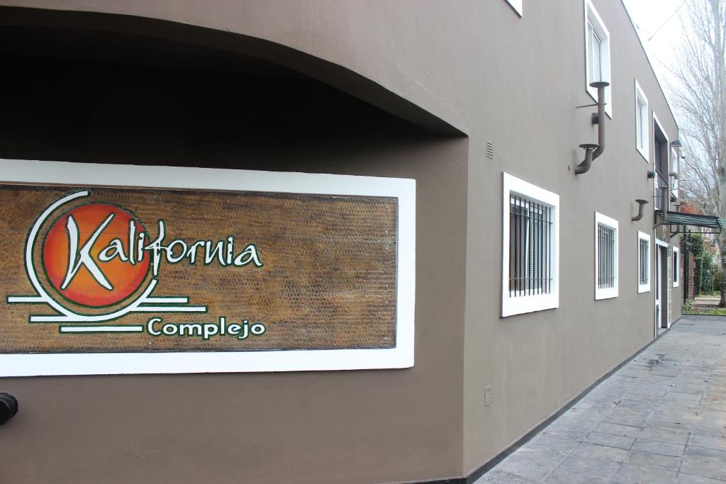 una señal para una empresa al lado de un edificio en Complejo Kalifornia en Pilar