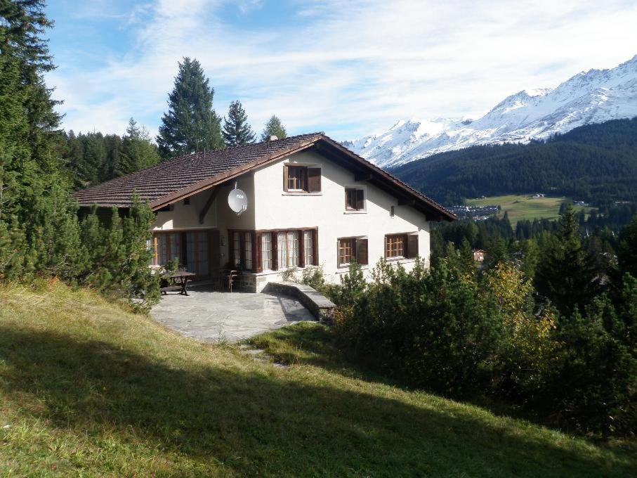 a house on a hill with mountains in the background at La Ruada (701 Bo) in Lenzerheide