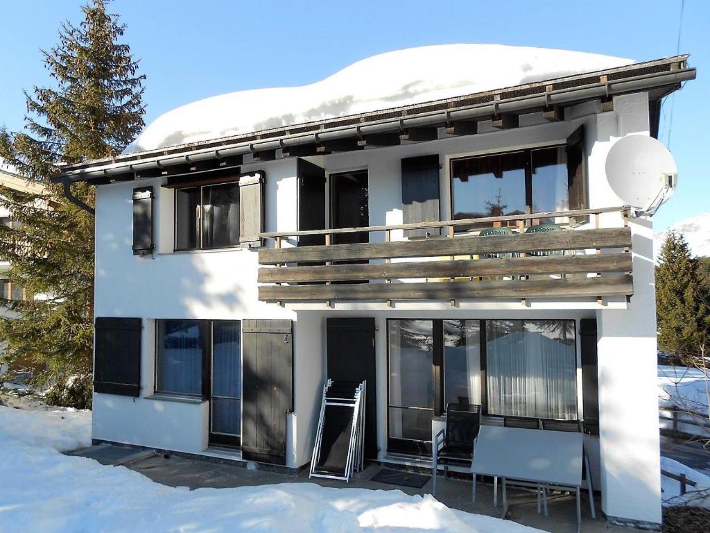 a white house with a balcony in the snow at Ulrike (709 Sh) in Lenzerheide