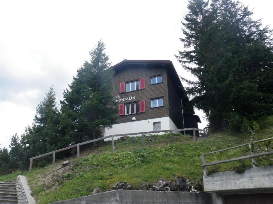 ein Gebäude auf einem Hügel mit Bäumen in der Unterkunft Montalin (452 Ti) 2. Stock in Valbella