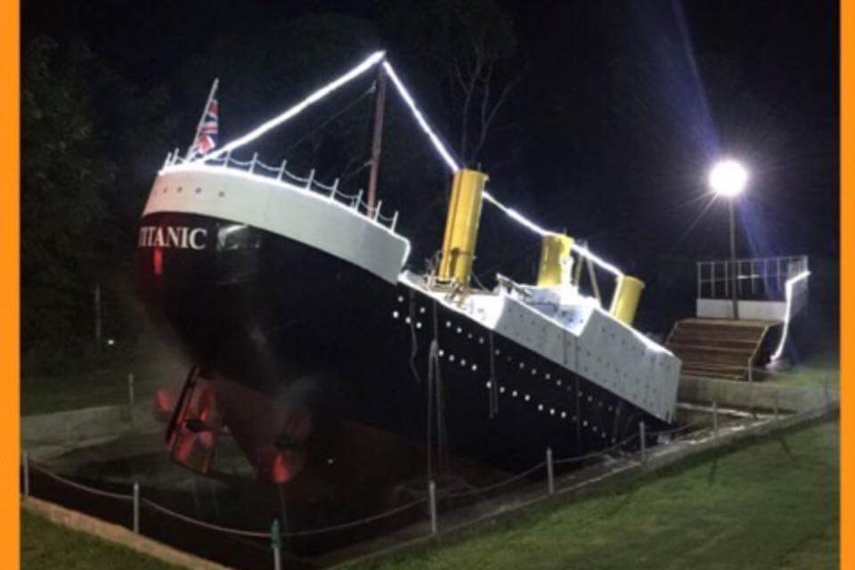 a large cruise ship sitting in a field at night at Titanic Park in Ratchaburi