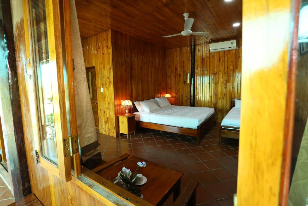 um quarto com uma cama num quarto com paredes de madeira em Boutique Lodge Can Tho Homestay em Can Tho