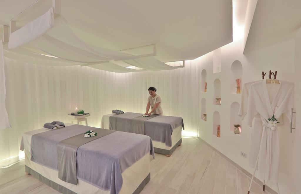 a woman sitting on two beds in a room at Code Samui Hotel in Mae Nam