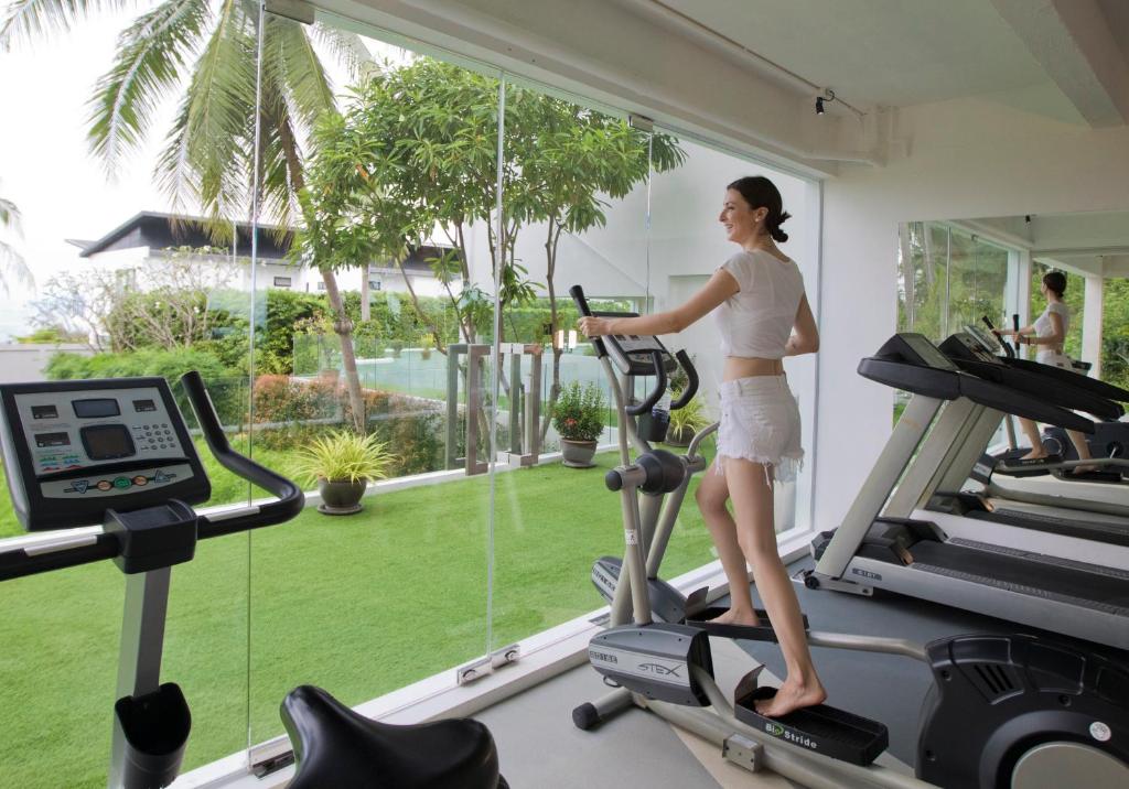a woman on a treadmill in a gym at Code Samui Hotel in Mae Nam