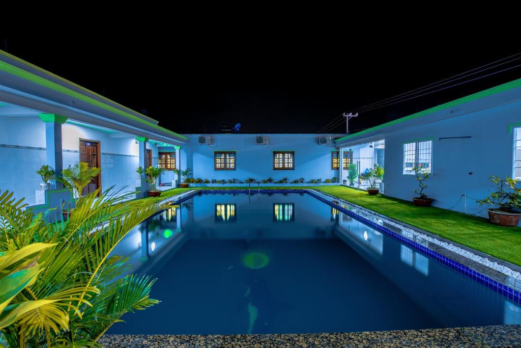 a swimming pool in the backyard of a house at night at Hotel Nguyên Toàn in Phu Quoc