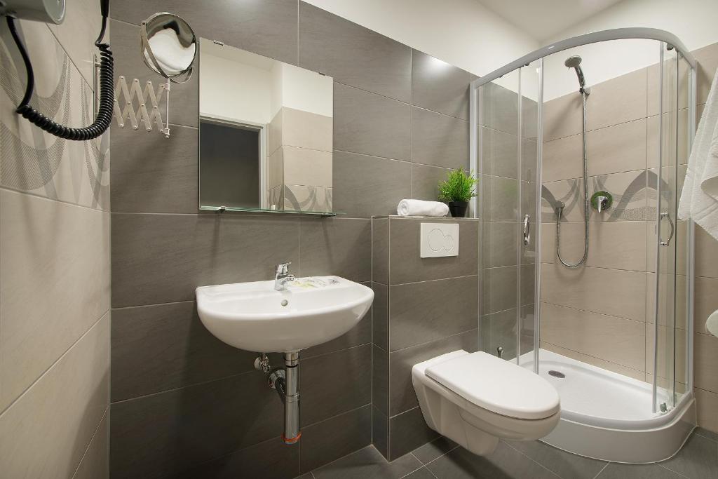 a bathroom with a sink and a toilet and a shower at Hotel Energie in Prague