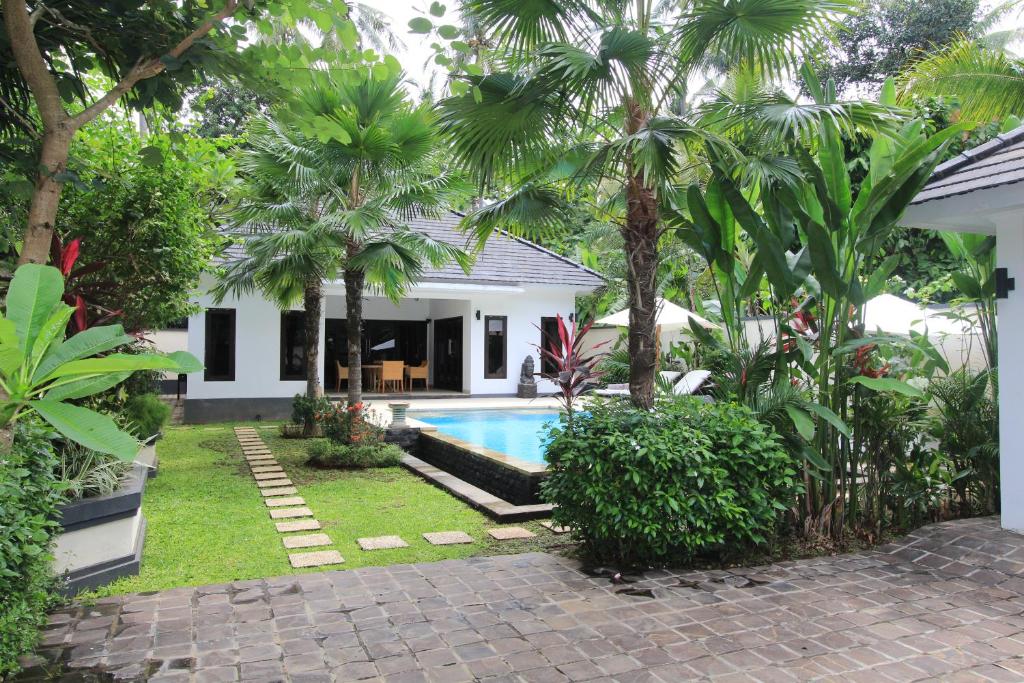 a backyard with a swimming pool and a house at Villa Kupu Kupu Lovina in Lovina