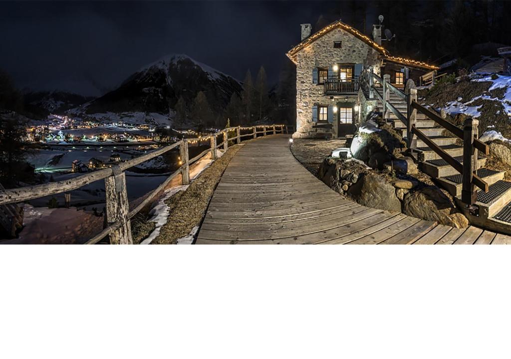 a wooden walkway leading to a house on a mountain at Chalet Charm in Livigno