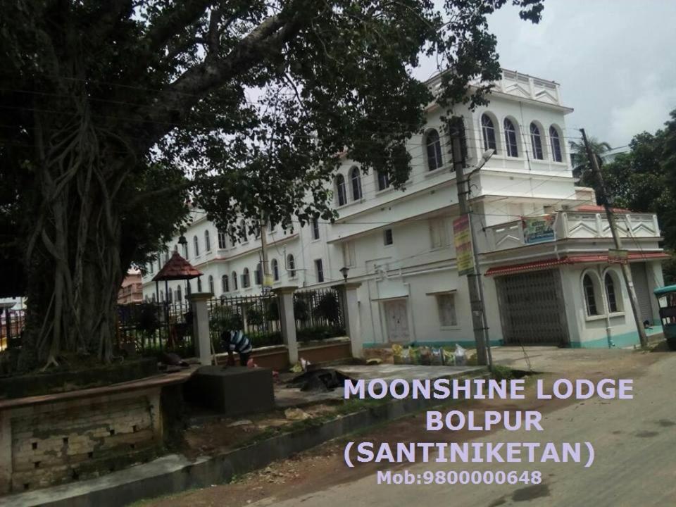 a white building with a tree in front of it at Moonshine Lodge in Bolpur