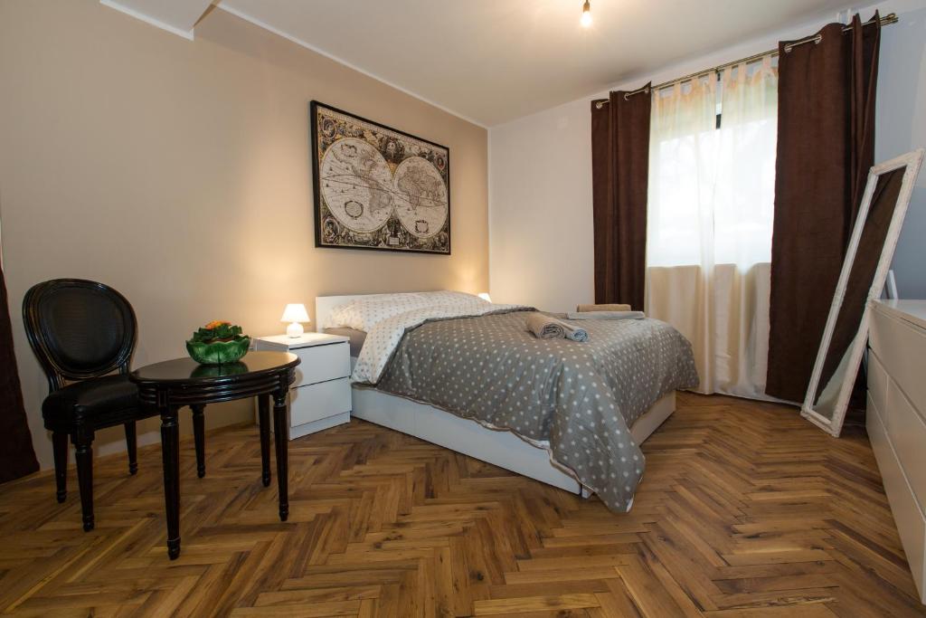 a bedroom with a bed and a table and a chair at New rooms & apartments in Ljubljana in Ljubljana