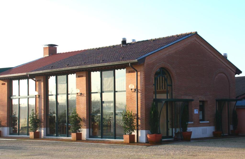 een bakstenen gebouw met grote ramen en potplanten bij Agriturismo Cabrele in Santorso