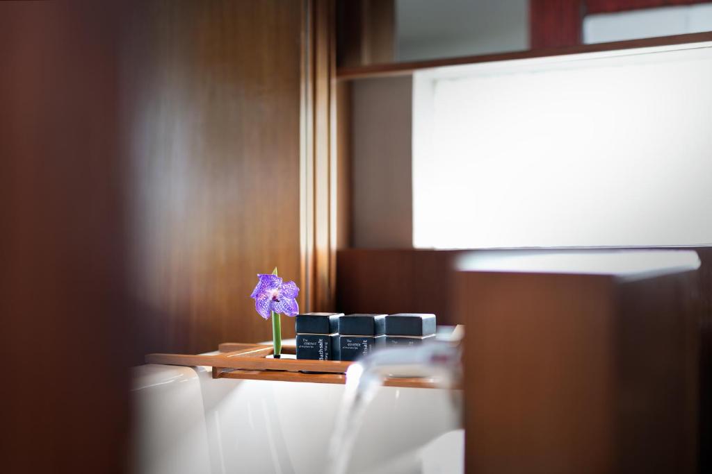 a purple flower in a vase on a shelf at Anantara Chiang Mai Resort in Chiang Mai