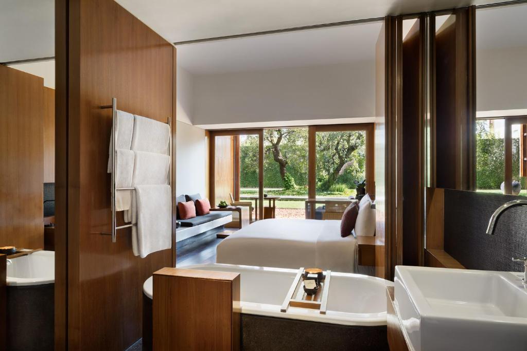 a bedroom with a bed and a bathroom with a sink at Anantara Chiang Mai Resort in Chiang Mai