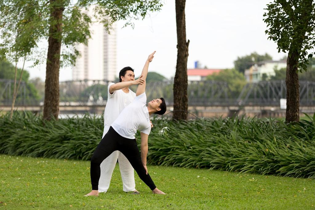 two men playing with a frisbee in a park at Anantara Chiang Mai Resort in Chiang Mai