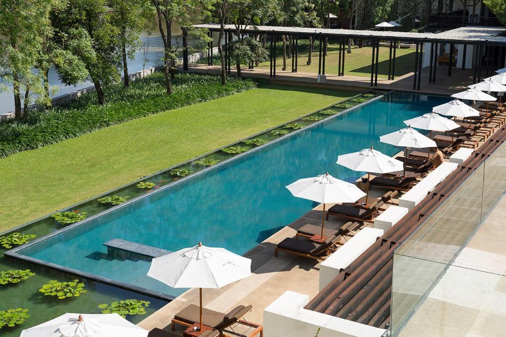 uma vista superior de uma piscina com guarda-sóis em Anantara Chiang Mai Resort em Chiang Mai