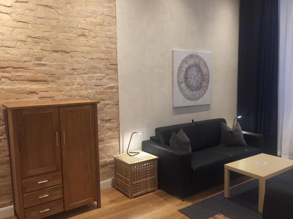 ein Wohnzimmer mit einem Sofa und einem Tisch in der Unterkunft City-Apartment Berlin Charlottenburg in Berlin