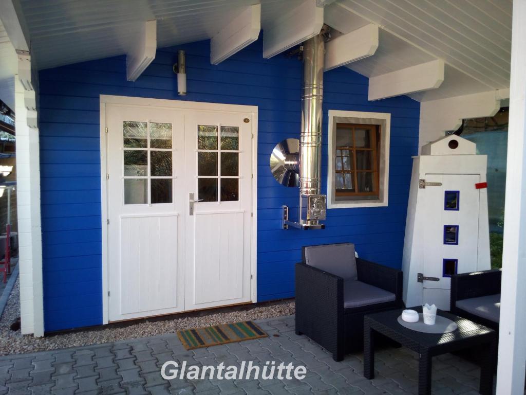 a blue house with a white door and a lighthouse at Glantalhütte in Glan-Münchweiler