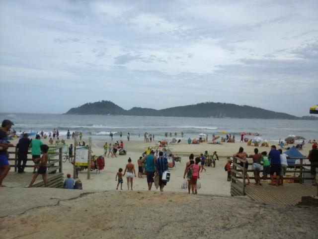 um grupo de pessoas caminhando em uma praia em Monsal Apartamento em Florianópolis