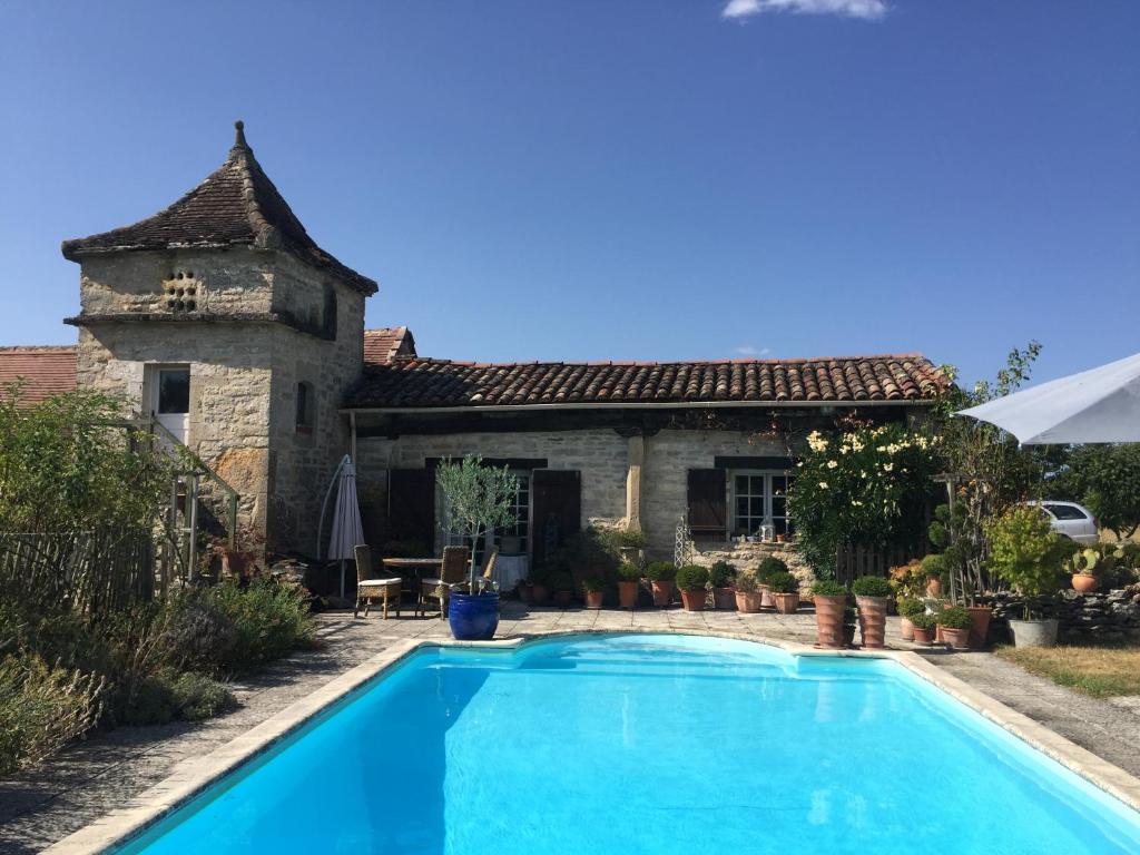 a villa with a swimming pool in front of a house at Pérard Chambres D’Hotes in Caylus