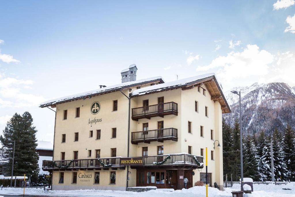 um hotel nas montanhas com neve no chão em Hotel Lyshaus em Gressoney-Saint-Jean