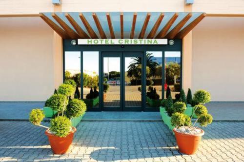 a hotel entrance with potted plants in front of it at Hotel Cristina in Rocca San Giovanni