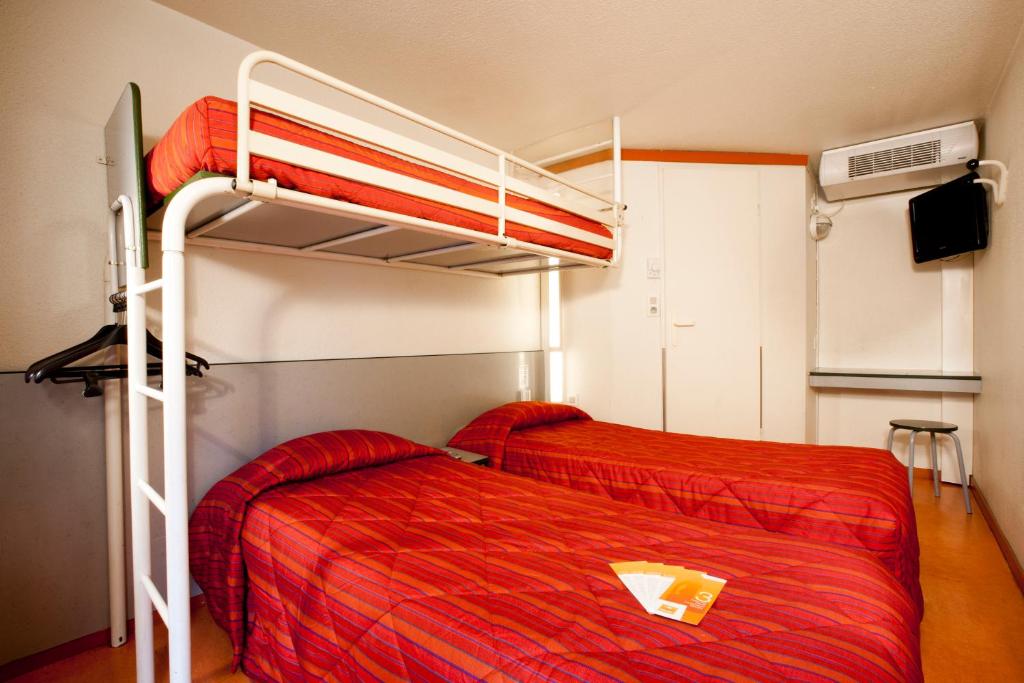 um quarto com 2 beliches e lençóis vermelhos em Premiere Classe Roanne Perreux em Perreux