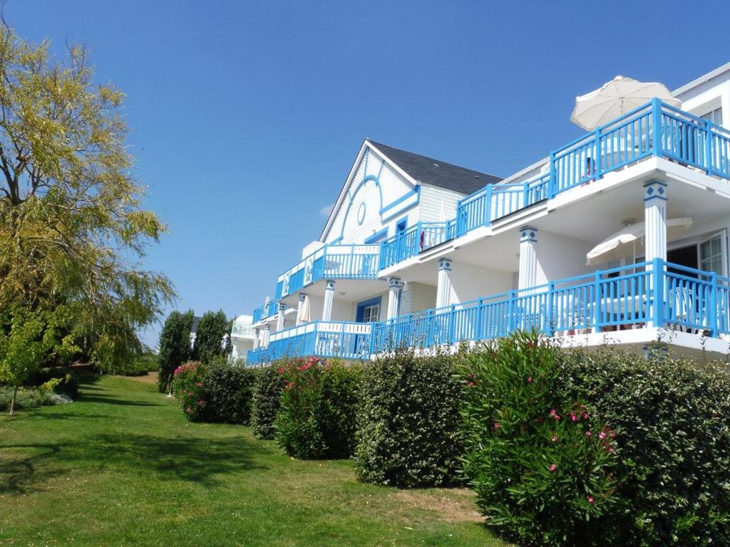 タルモンにあるAppartement 2 Pièces Port-Bourgenayの青いバルコニーと茂みのある大きな白い家