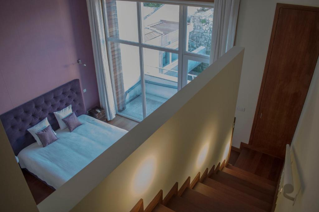 a bedroom with a bed and a large window at Book House in Porto