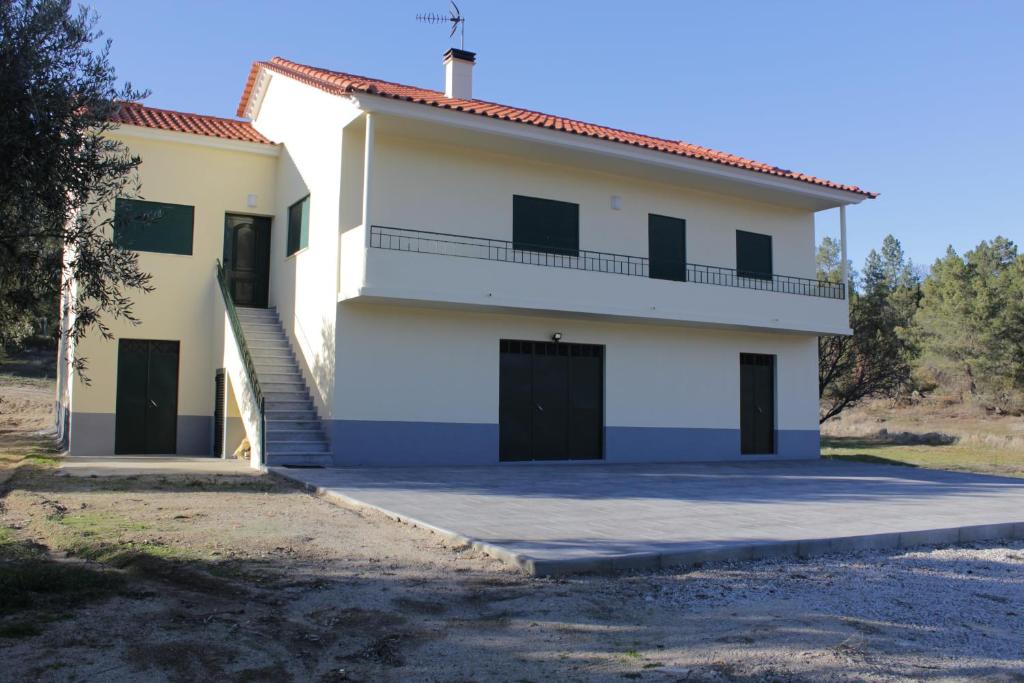 una gran casa blanca con una escalera delante de ella en Quinta Chão do Nabal, en Belmonte