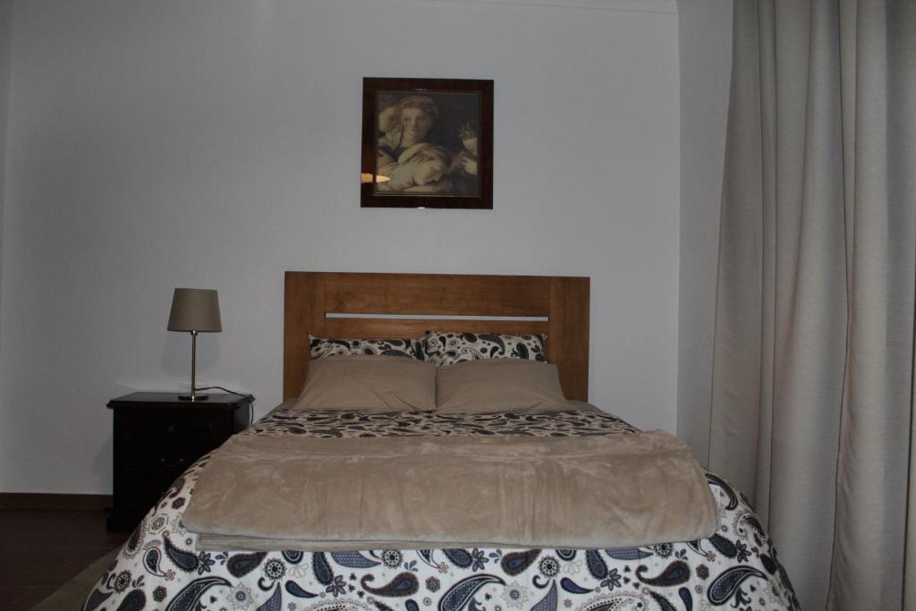 um quarto com uma cama e uma fotografia na parede em Quinta Cho do Nabal em Belmonte