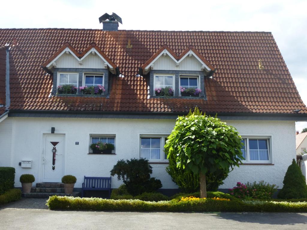 Casa blanca con techo rojo en Ferienwohnung Haus Nr. 11, en Warendorf