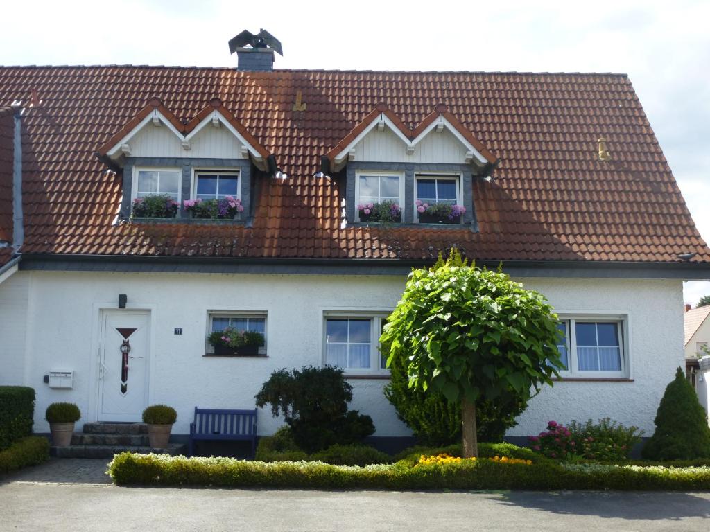 ein weißes Haus mit einem roten Dach in der Unterkunft Ferienwohnung Haus Nr. 11 in Warendorf