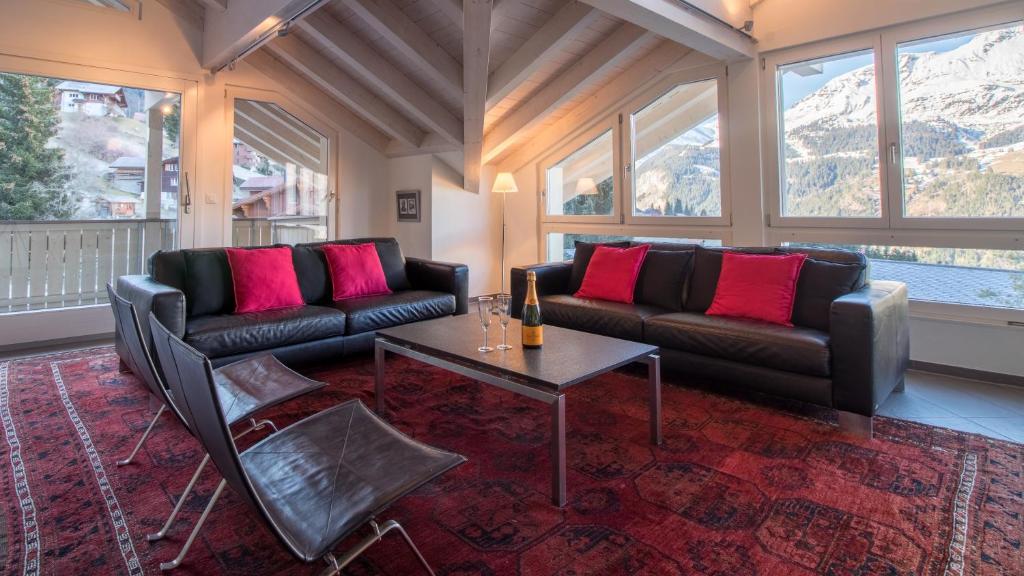 a living room with two couches and a table at Chalet Brunner Penthouse in Wengen