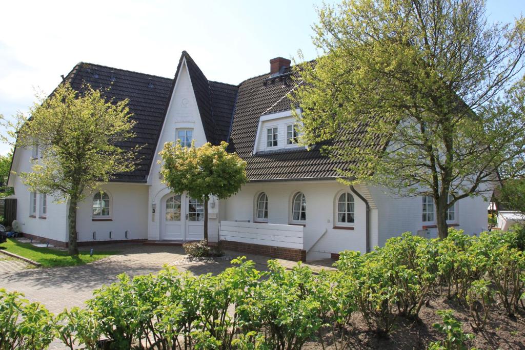 ein weißes Haus mit schwarzem Dach in der Unterkunft Witt-Hingst in Westerland