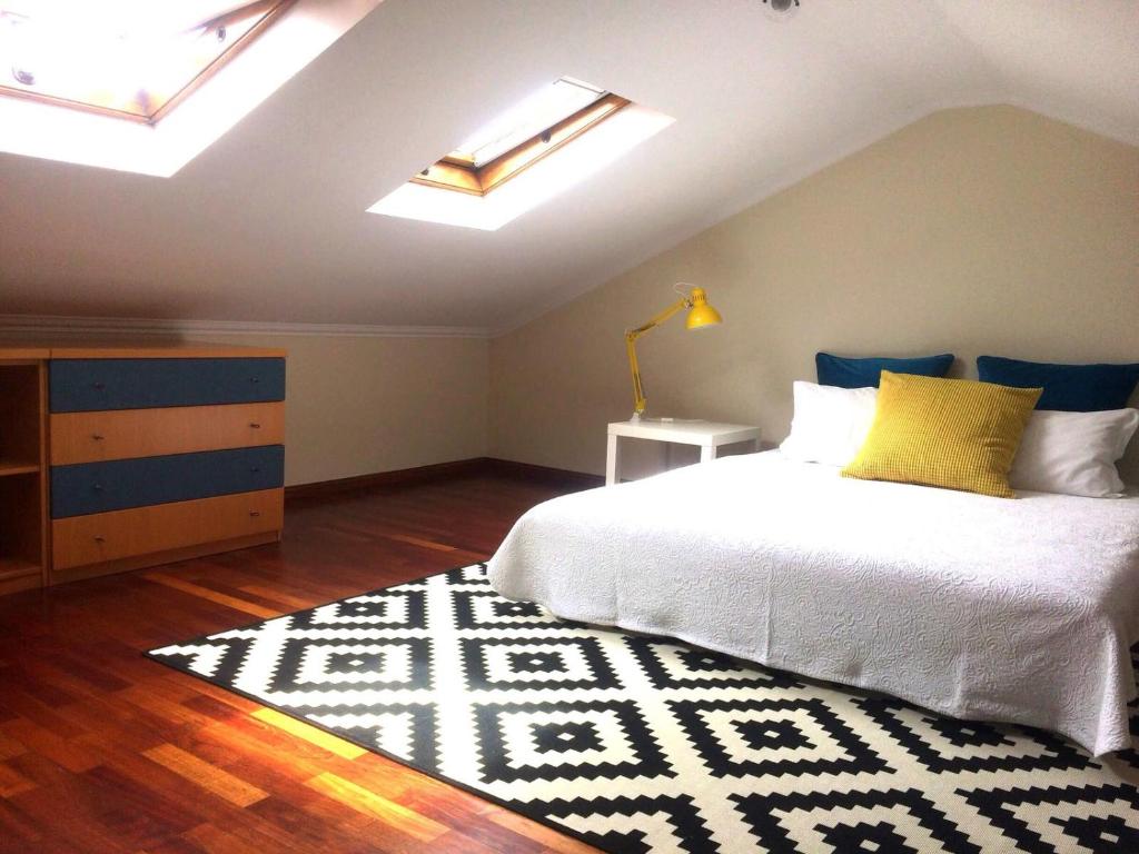 a bedroom with a white bed and a rug at Apartment Vedória in Viana do Castelo