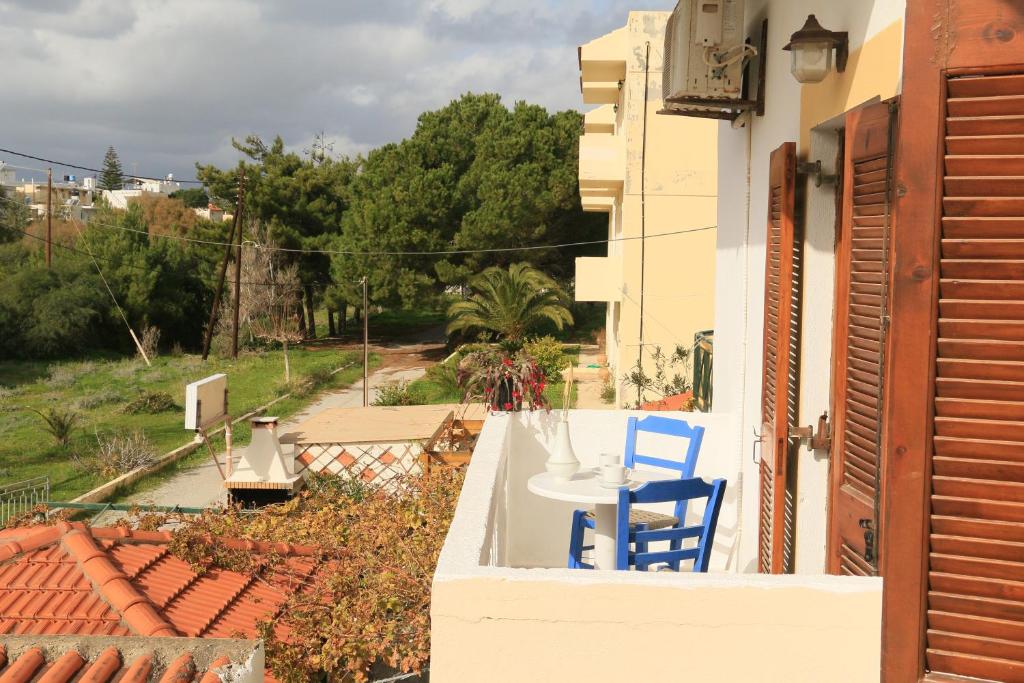 a balcony with two blue chairs and a table at Rent Rooms Katerina in Kalamaki Heraklion