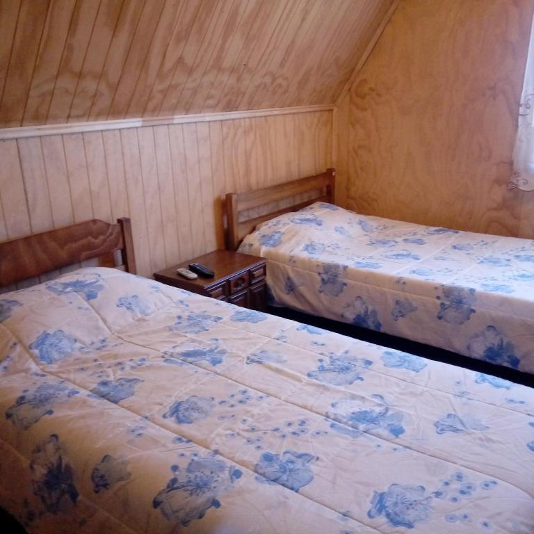 a room with two beds and a table with two beds w obiekcie Casa Lange w mieście Valdivia